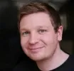 Headshot of Jaymeh with slightly smiling face